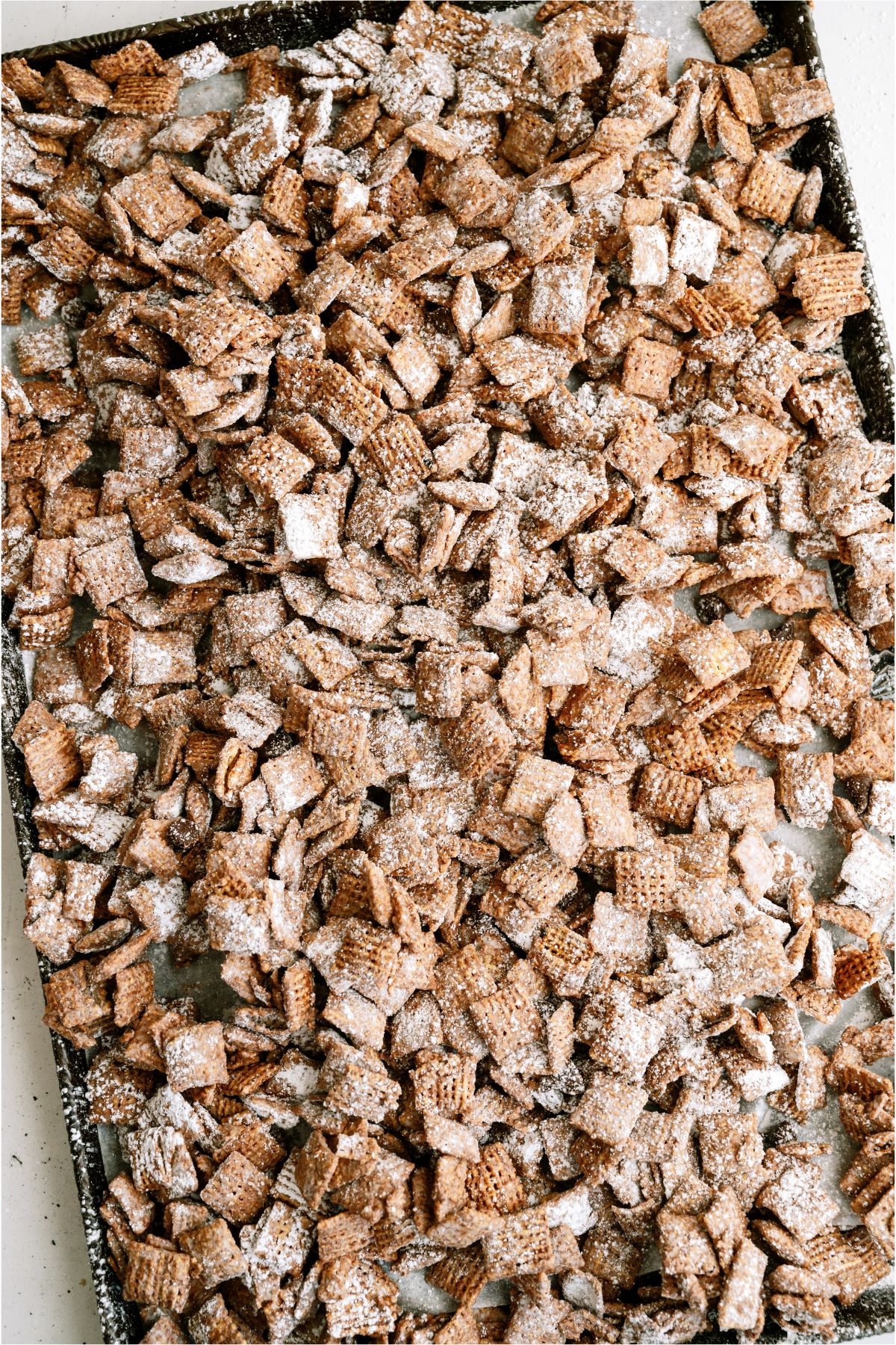 Large baking sheet filled with Muddy Buddies (Puppy Chow)