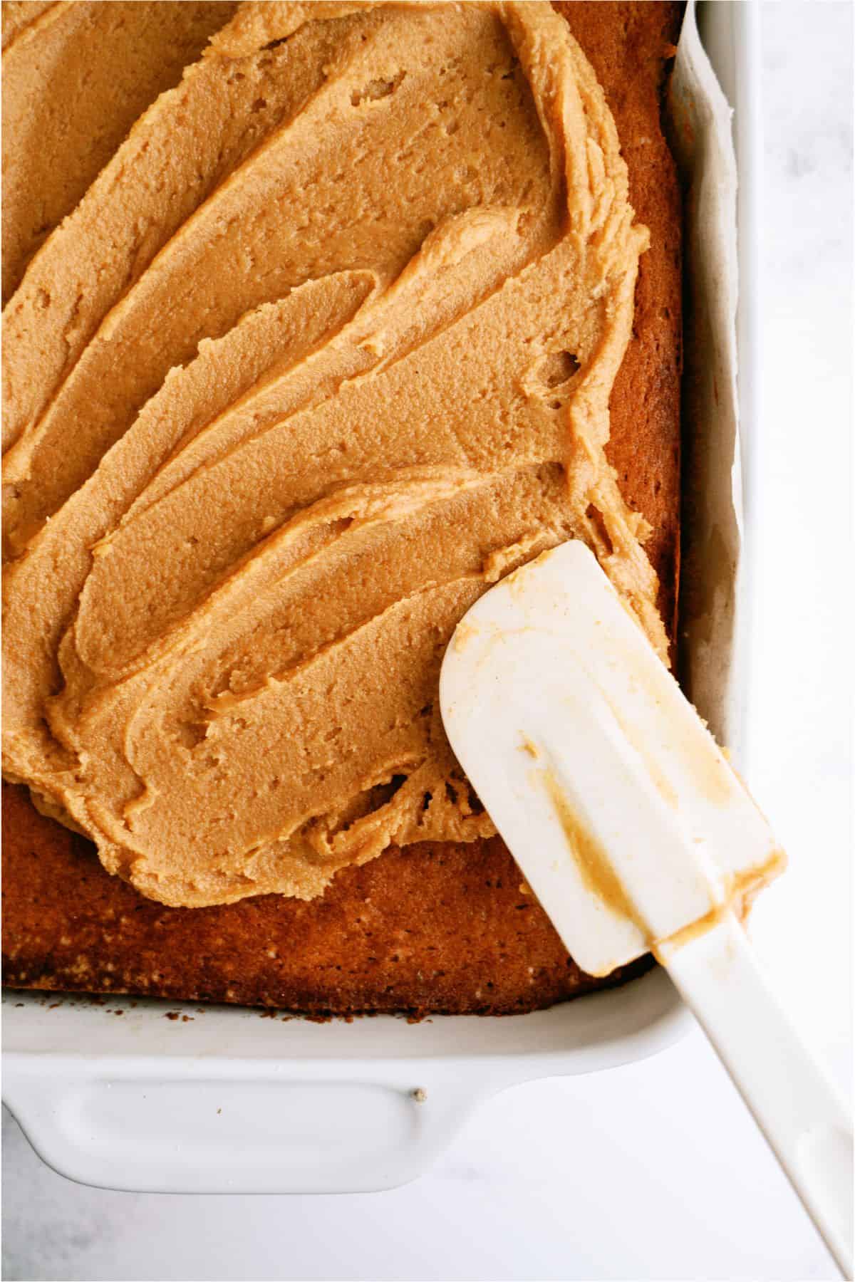 Frosting Peanut Butter Sheet Cake in pan