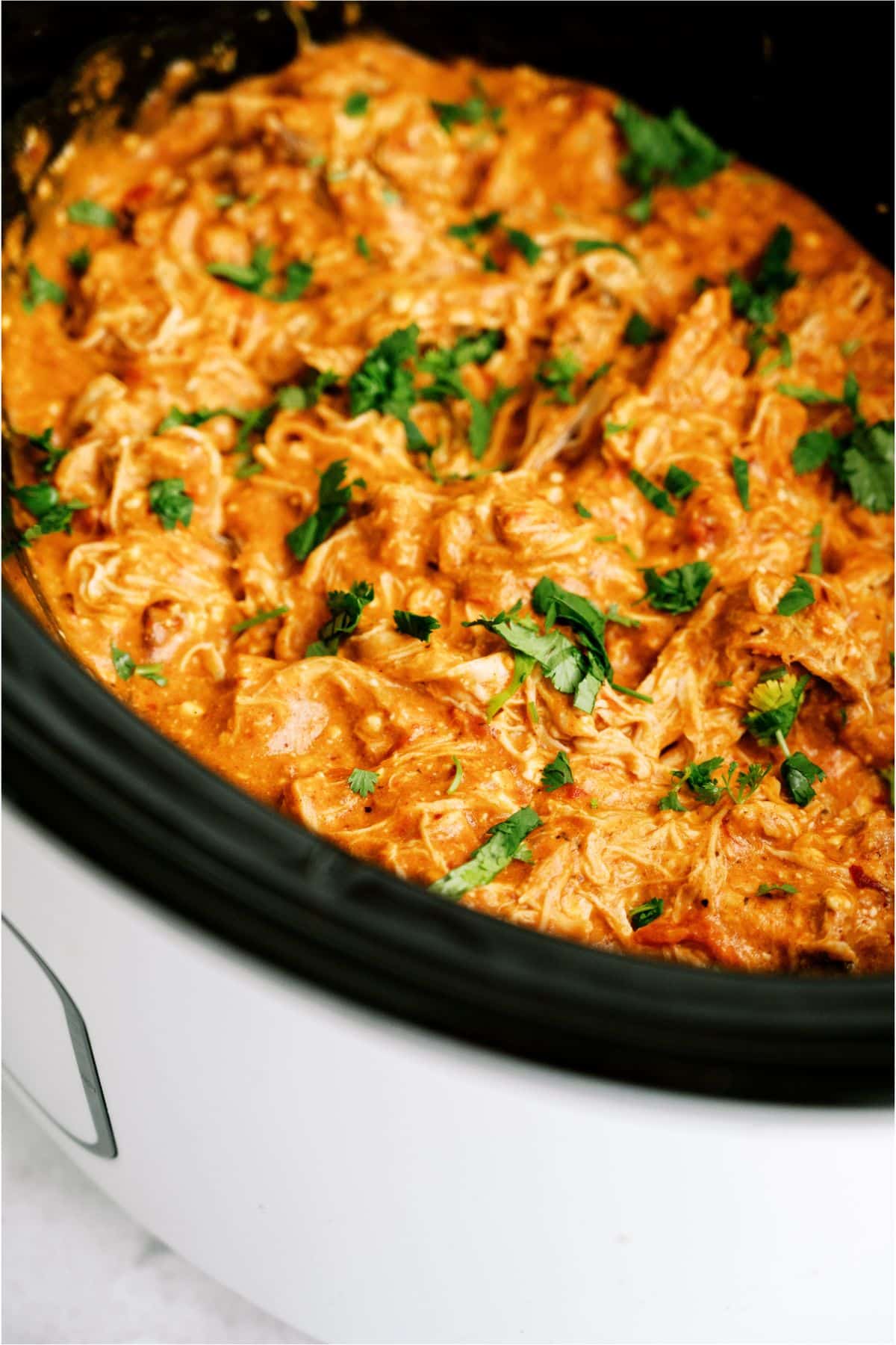 A slow cooker filled with Slow Cooker Queso Chicken