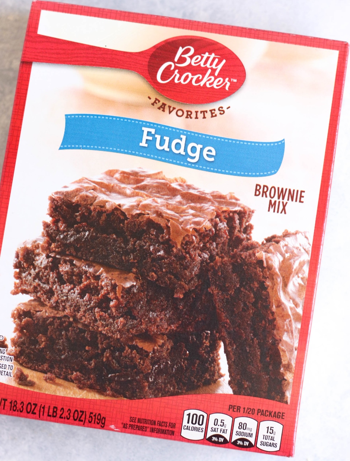 A box of Betty Crocker Fudge Brownie Mix, featuring an image of baked brownies and nutritional information on the front.