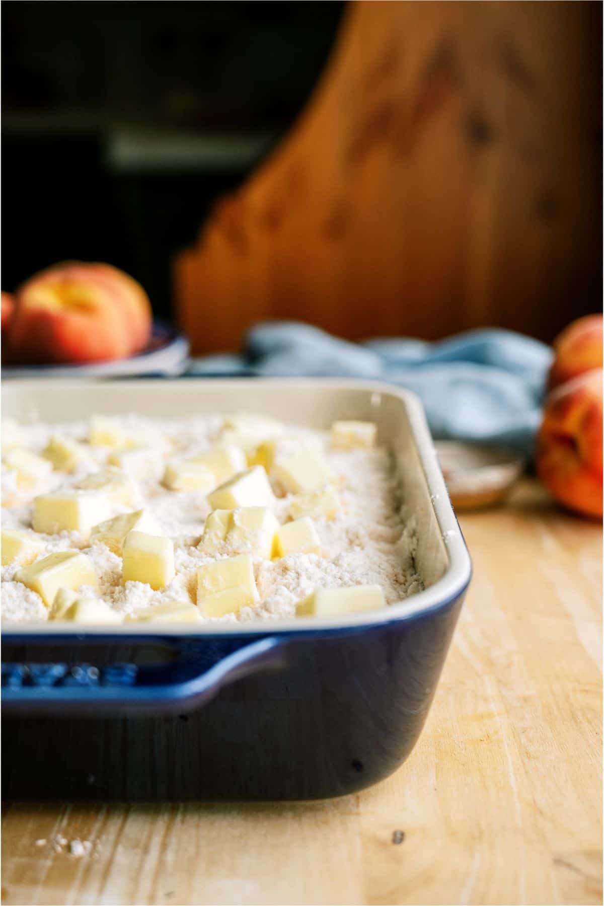 Cubed butter on top of cake mix in baking dish