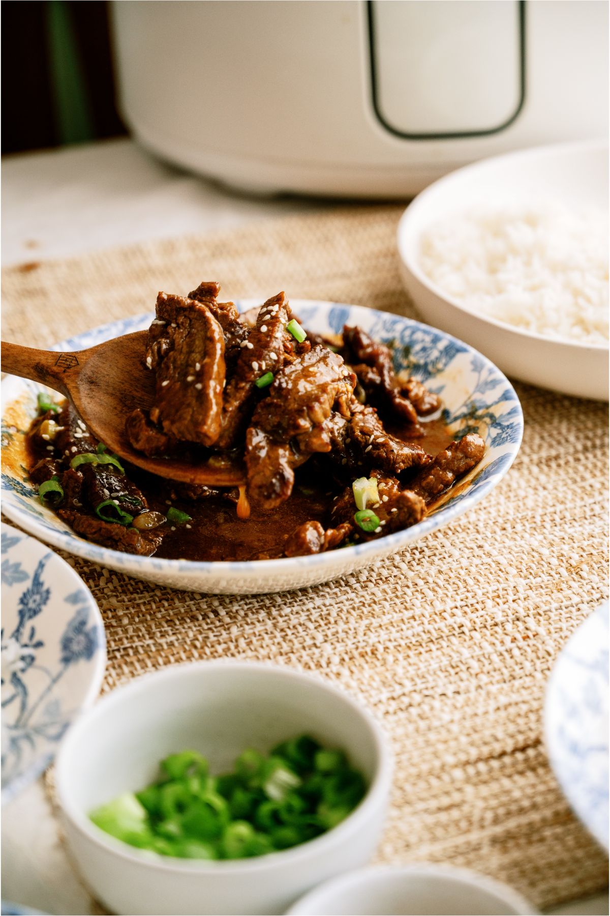 A bowl of Slow Cooker Korean Beef with a wooden spoon