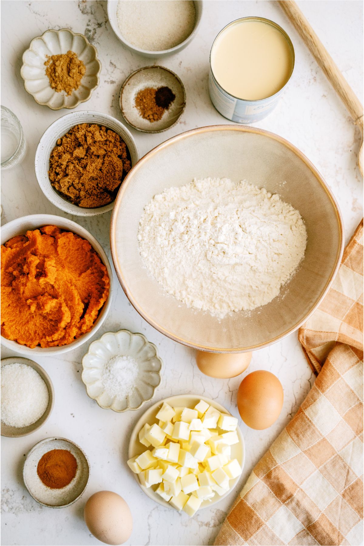 Ingredients needed to make homemade pie crust and homemade pumpkin pie on a countertop.