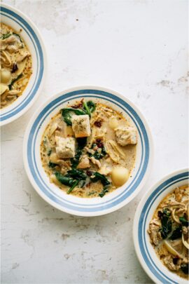 Top view of 3 bowls of Chicken Soup sitting on a countertop with the middle bowl centered in the picture.