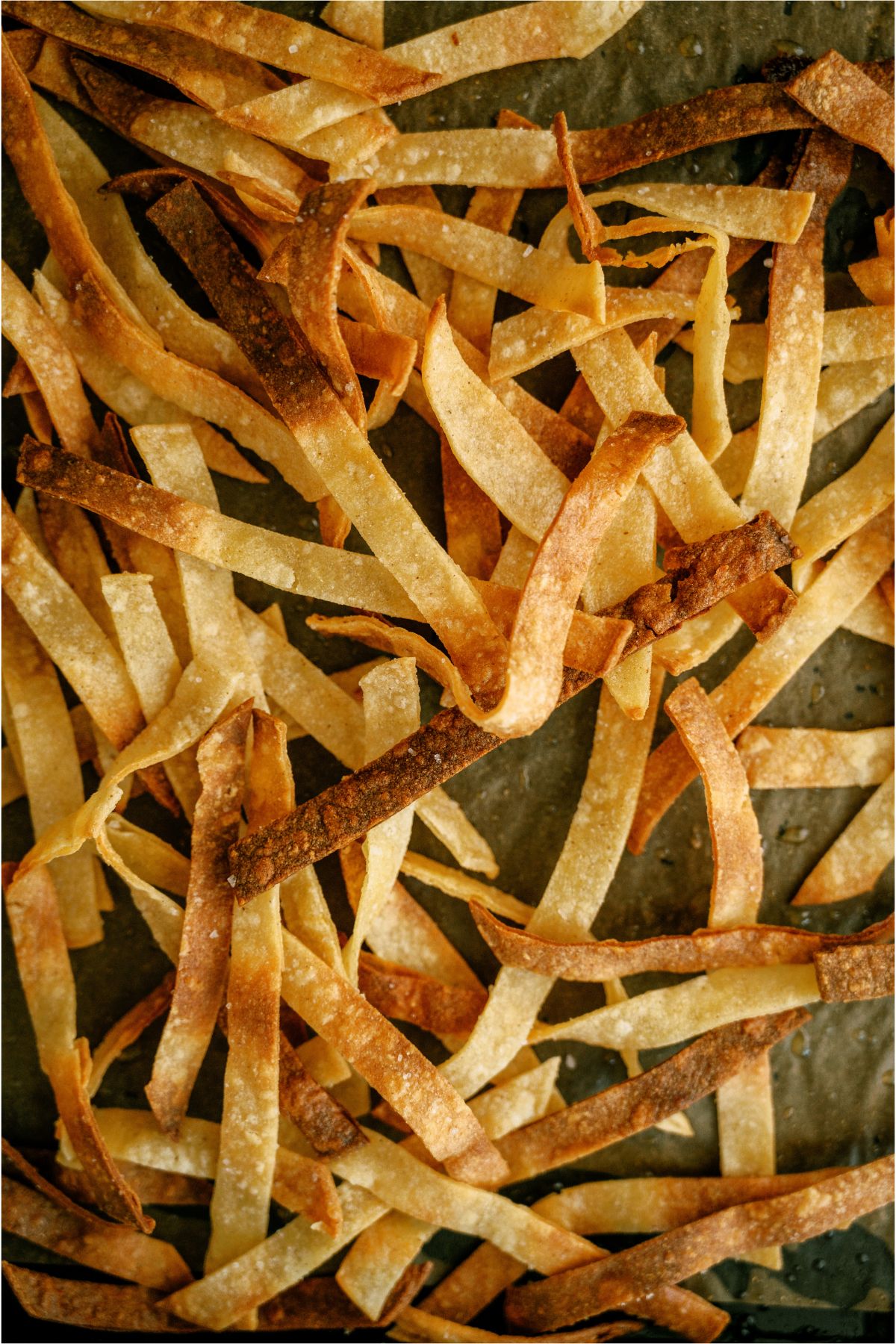 A sheet pan with homemade tortilla strips baked.