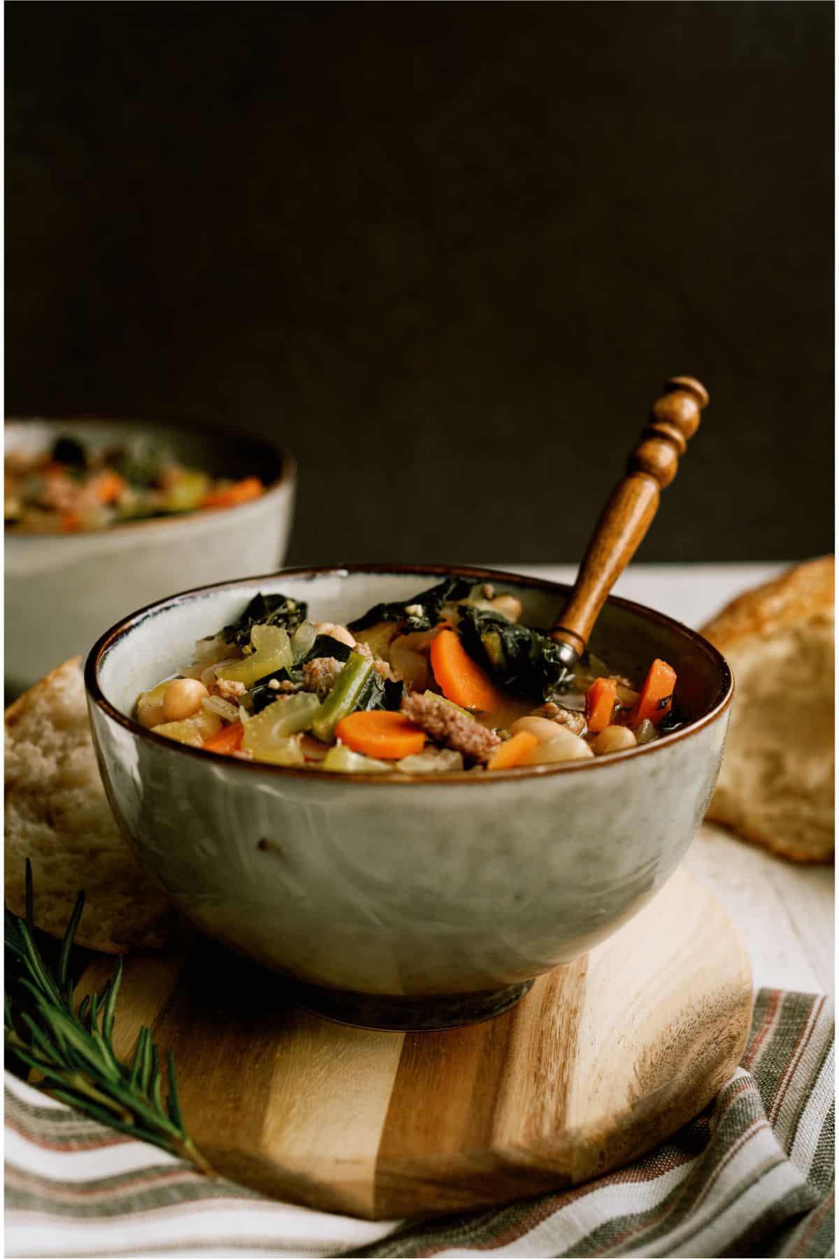 A green bowl filled with Tuscan White Bean Soup and a spoon.