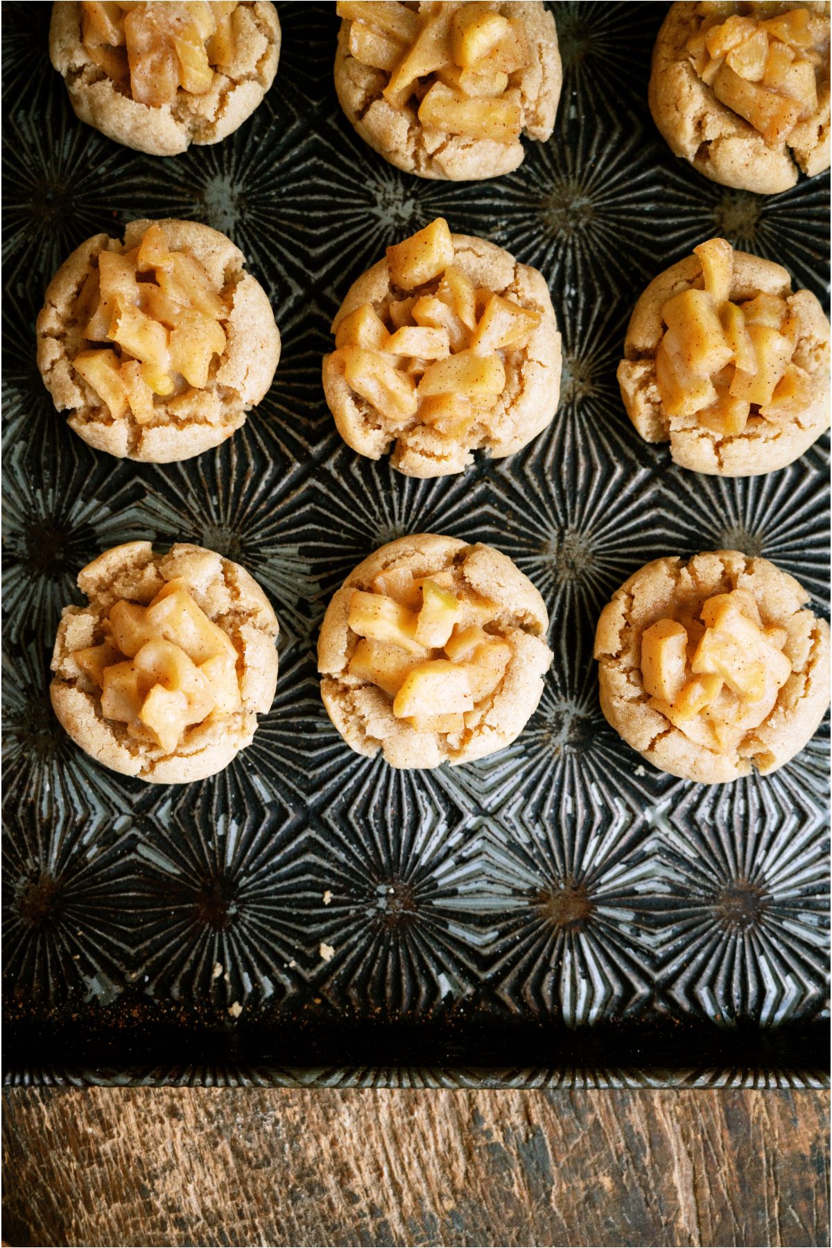 Top view of 9 Apple Pie Cookies lined up on a baking sheet.