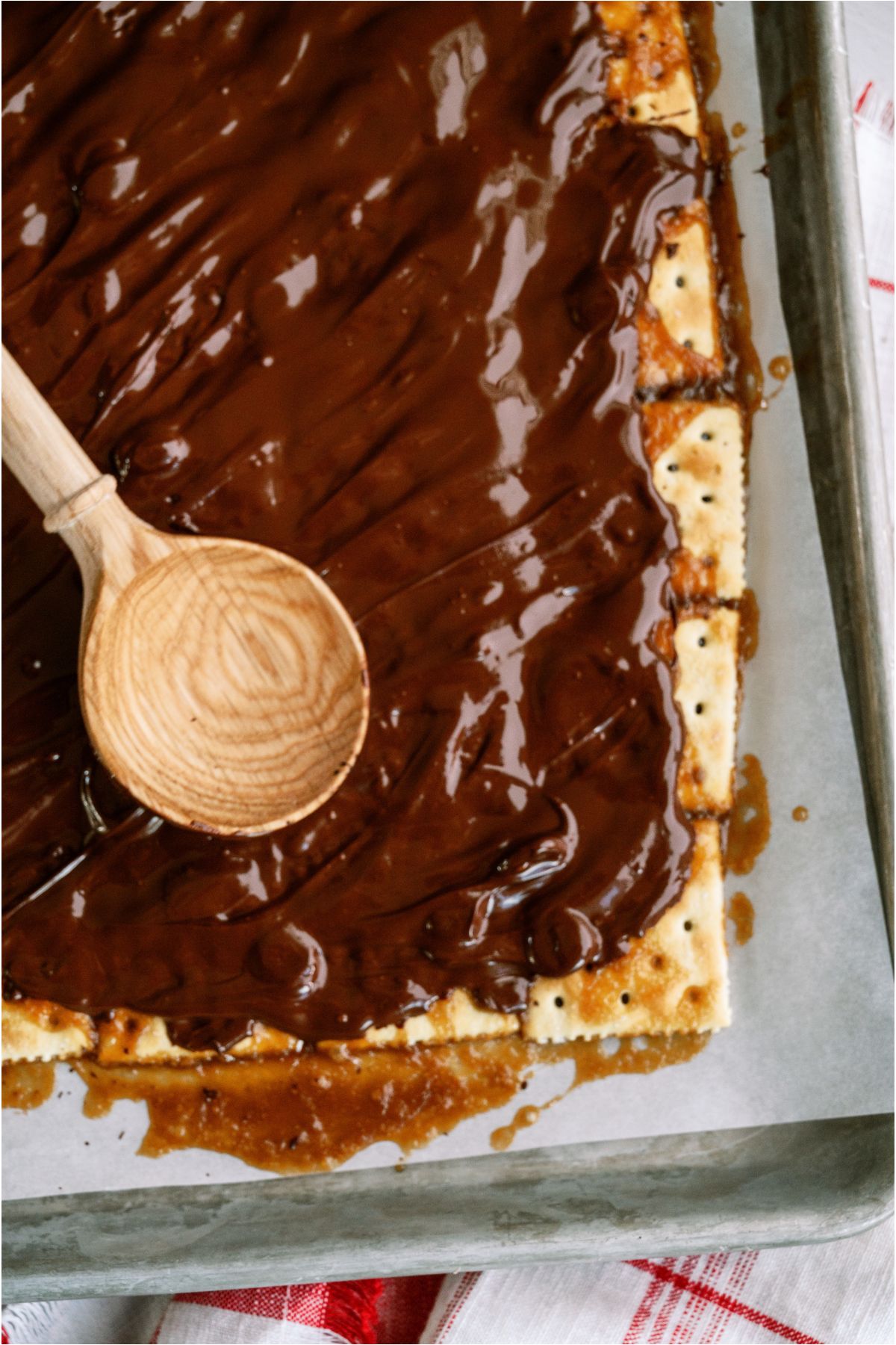 A wooden spoon spreading dark chocolate melted.