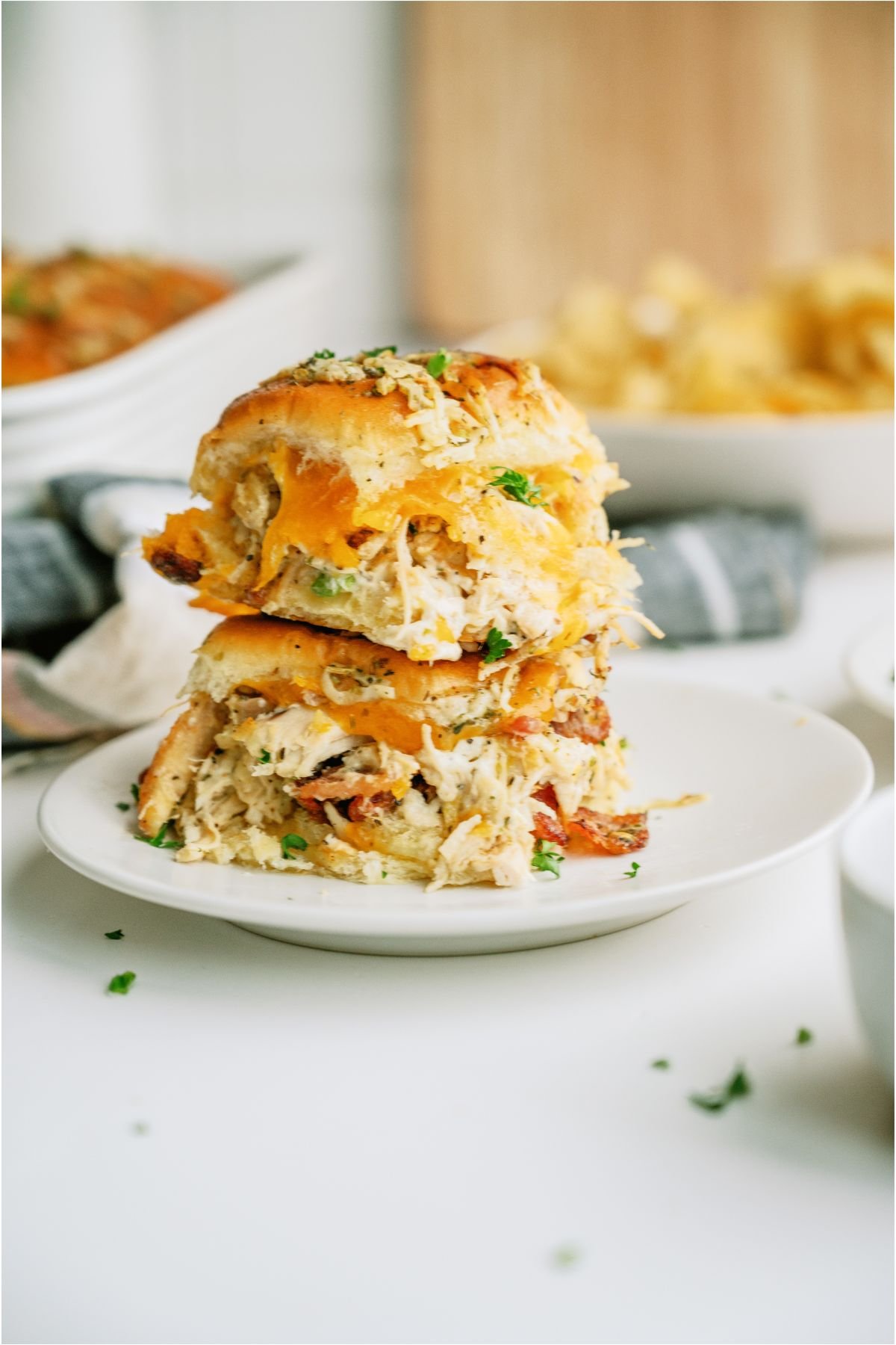 Two Crack Chicken Sliders stacked on top of each other on a white plate.