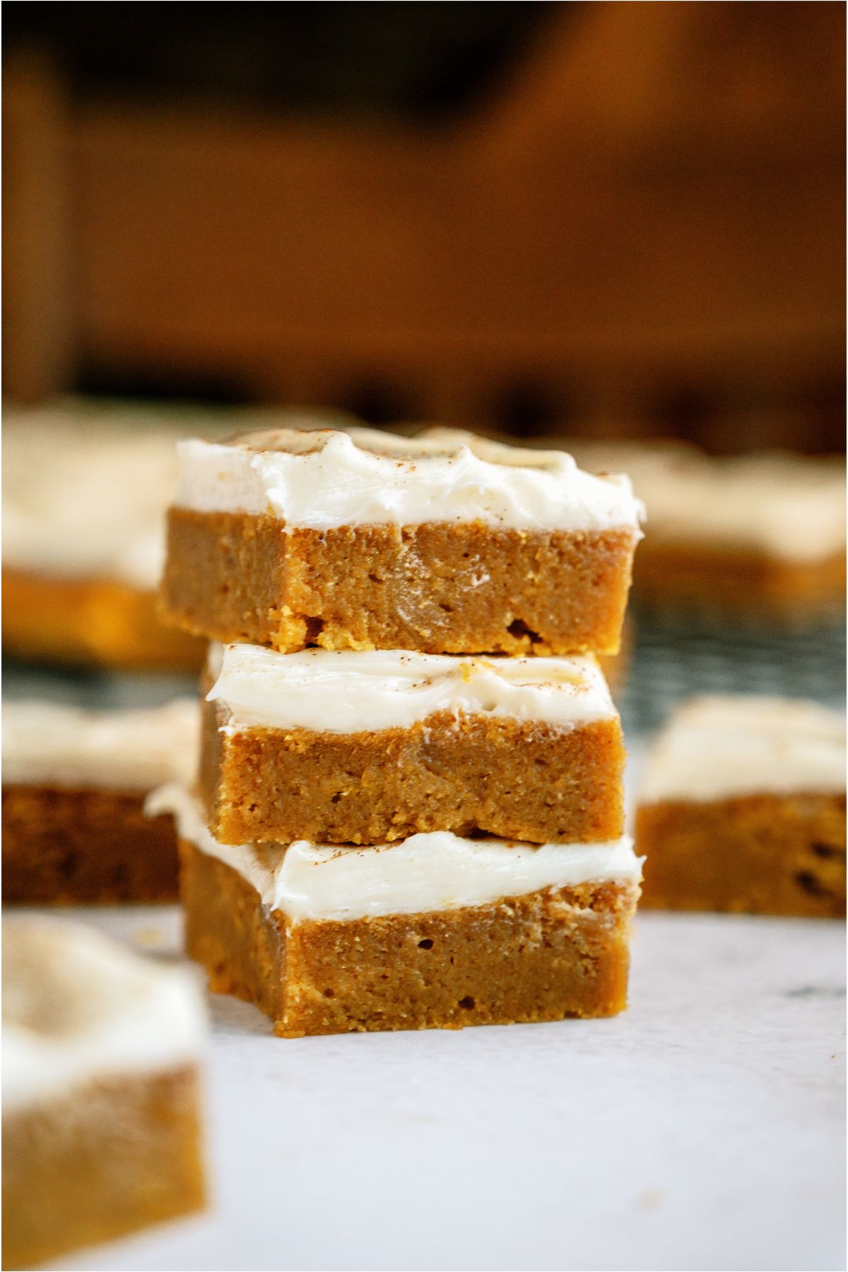 3 Pumpkin Bars stacked with other Pumpkin Bars surrounding them.