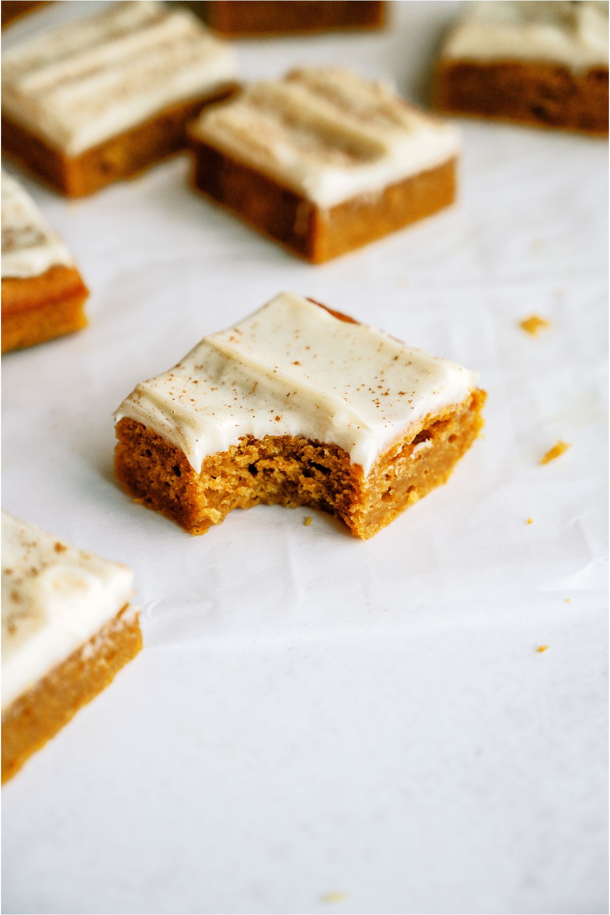 Pumpkin Bars on a countertop with one missing a bite from it.