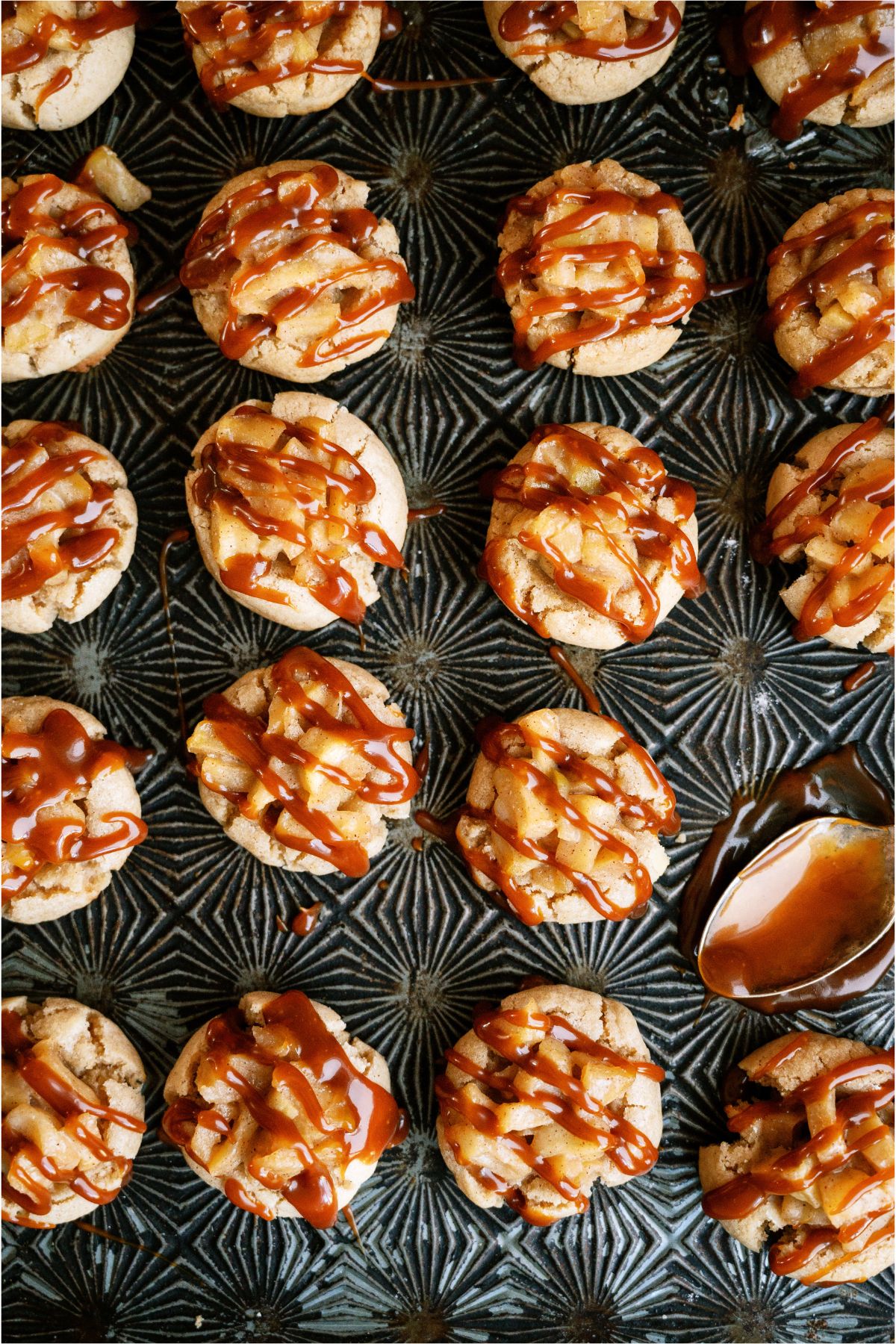 Top view of a sheet pan of Apple Pie Cookies drizzled with caramel sauce.