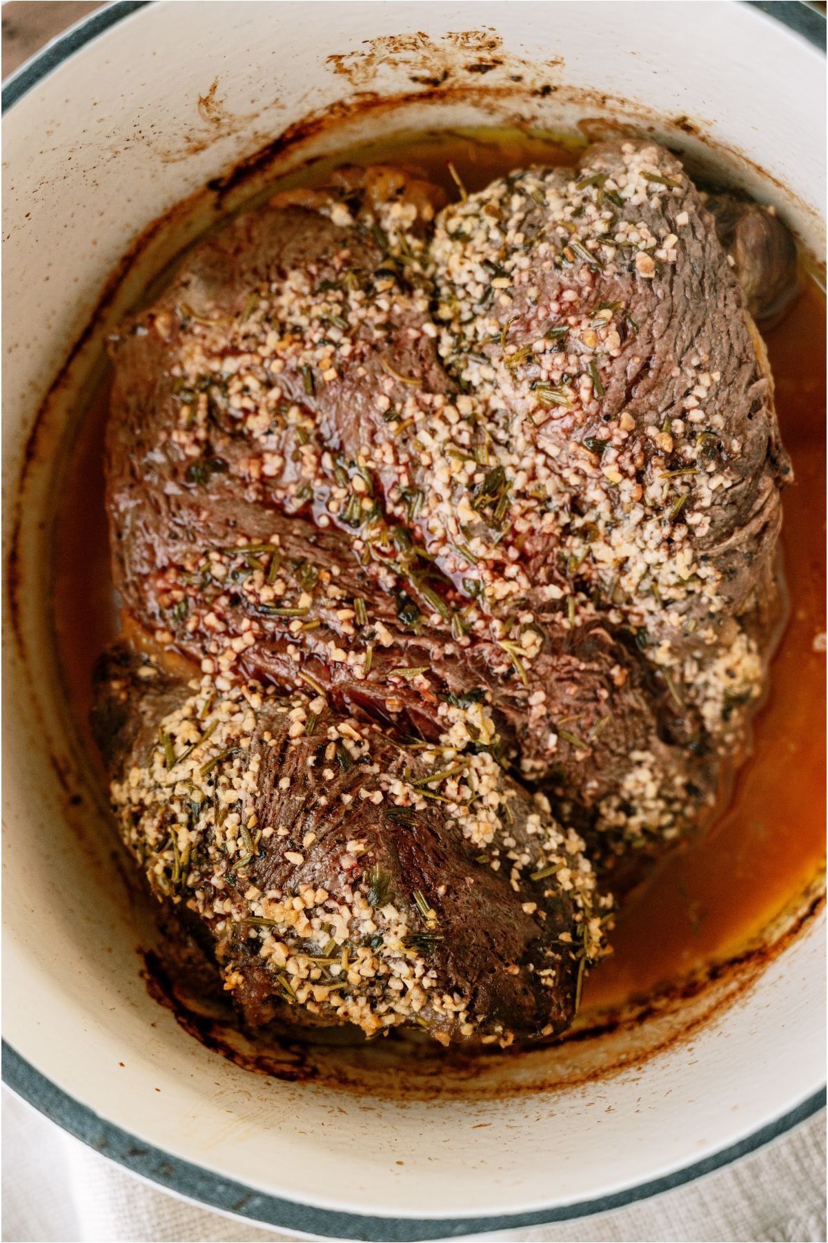 A cooked Garlic Butter Beef Roast in a large roasting pot.