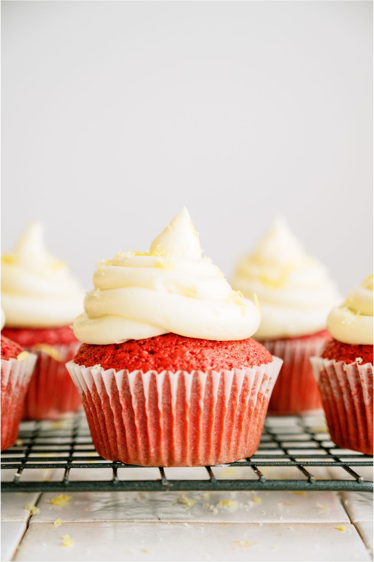 Red Velvet Cupcakes frosted on top of a cooling rack.