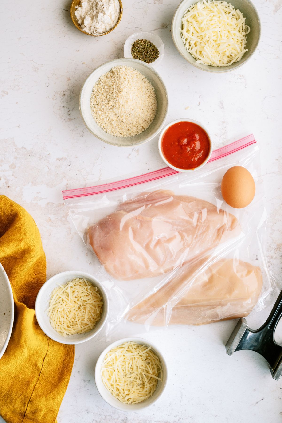 Ingredients needed to make Chicken Parmesan.