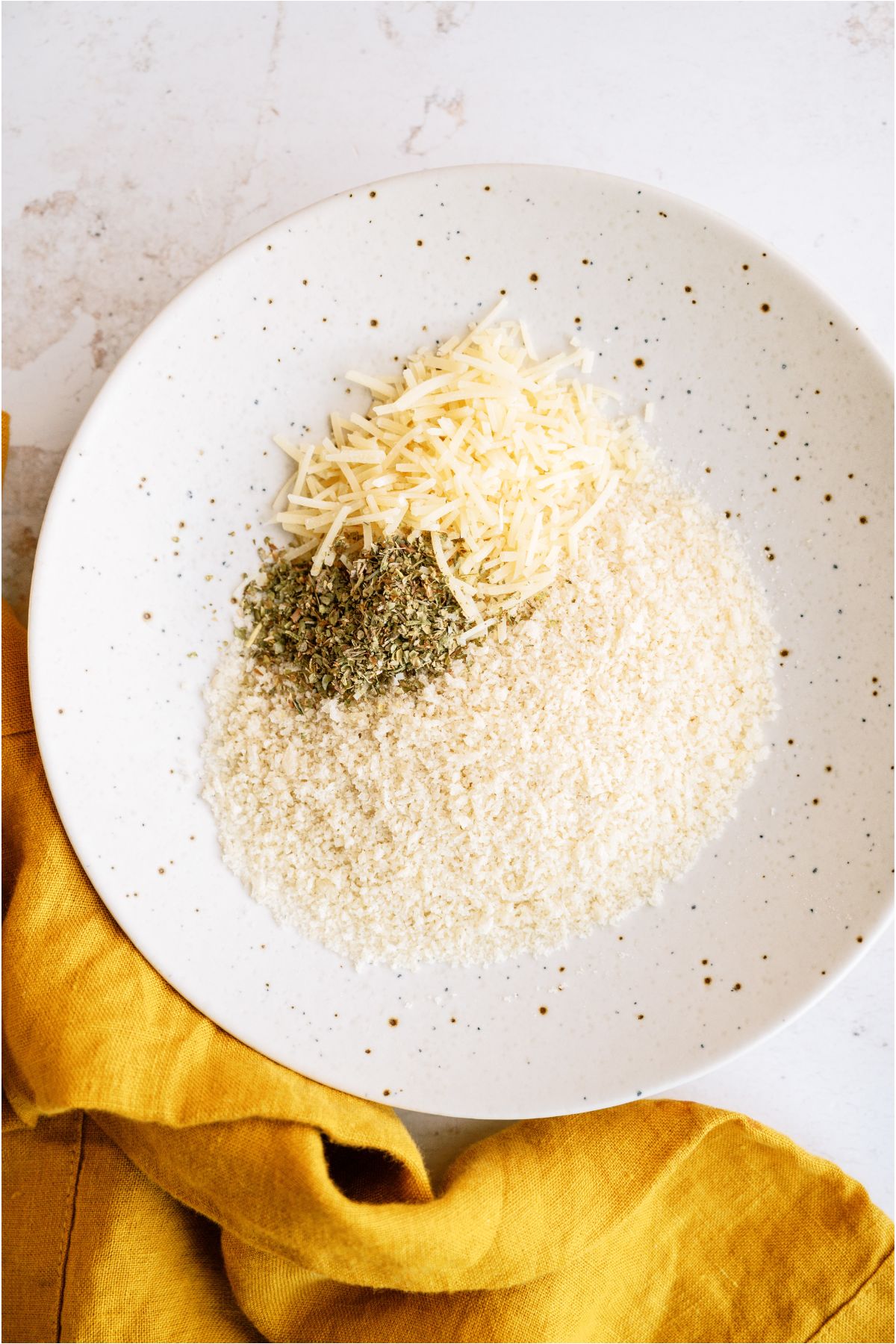 Flour, Parmsan Cheese and Italian seasoning in a bowl together.