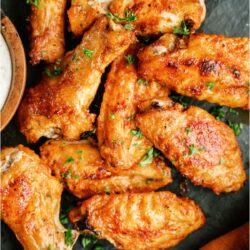 Top view of Crispy Baked Chicken Wings on a green background.