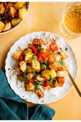 Top view of a plate of rice topped with Sheet Pan Hawaiian Chicken with a fork.