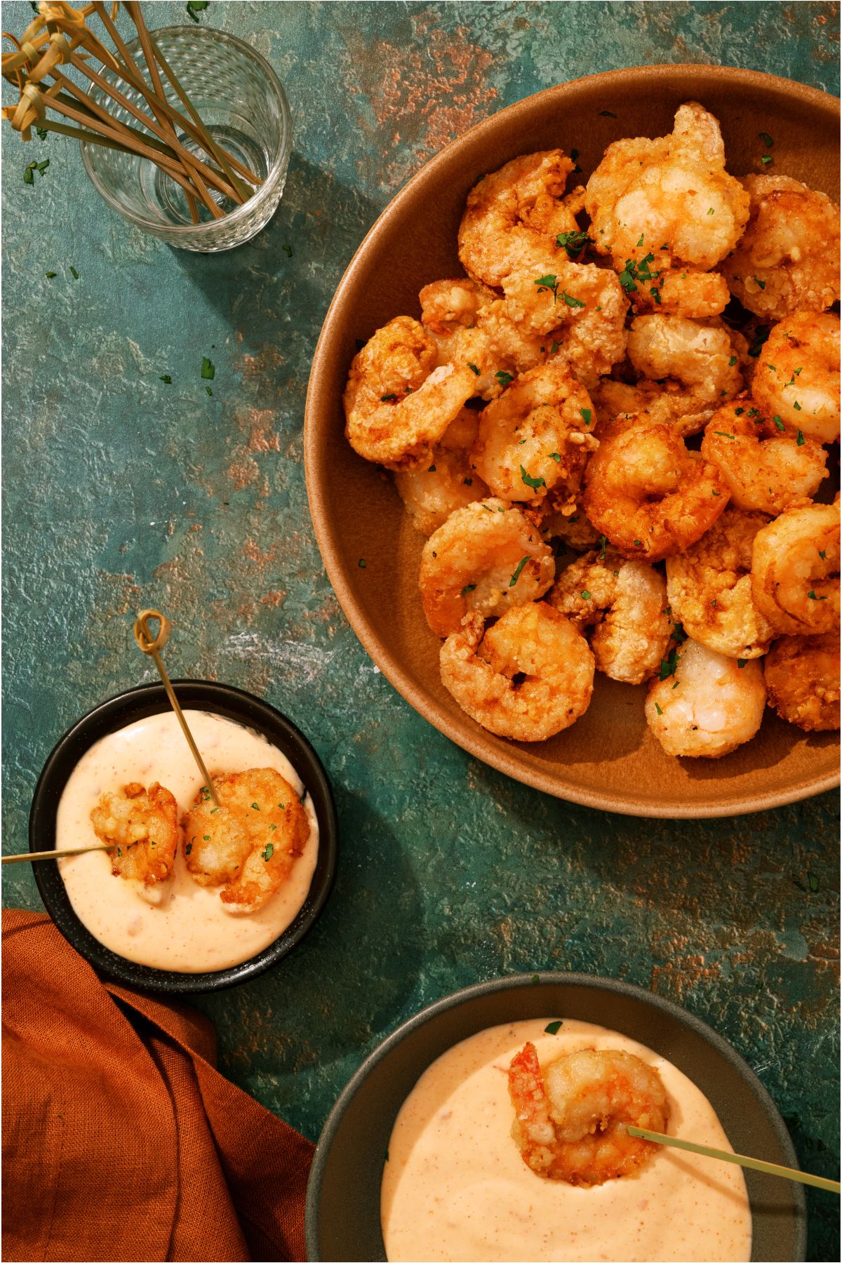 Top view of a bowl of Bang Bang Shrimp with 2 small bowls of dipping sauce with shrimp in the dipping sauce.