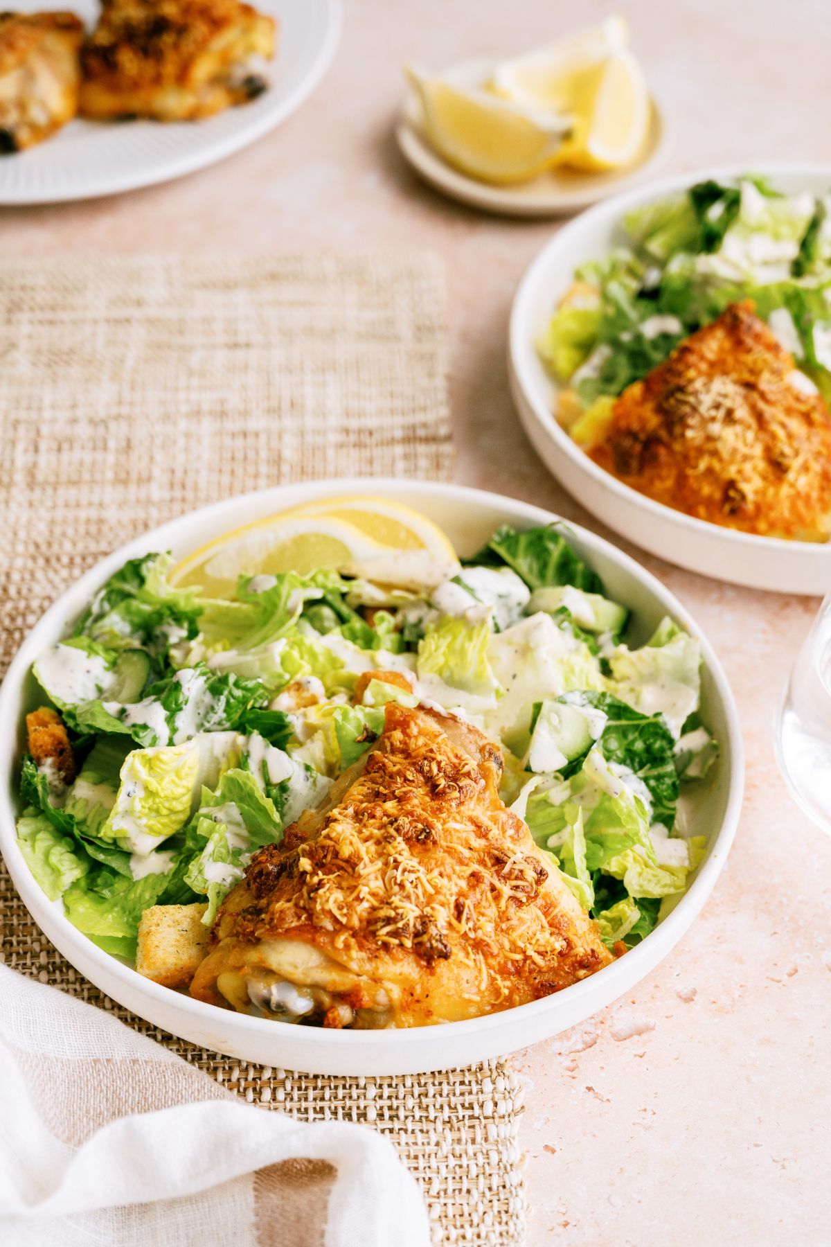 2 plates with Creamy Garlic Parmesan Chicken and salad on them.