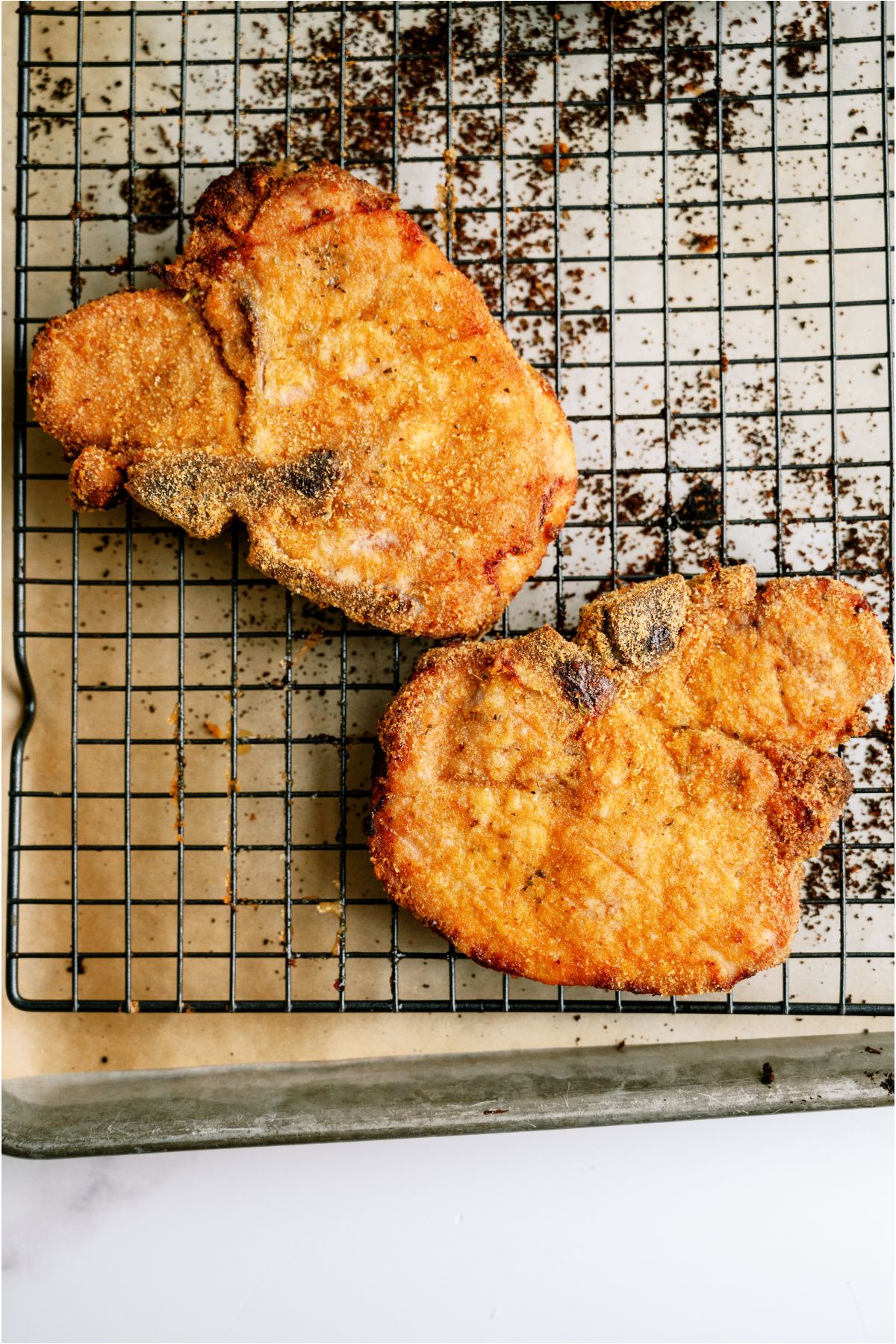 Crispy, baked Shake And Bake Pork Chops on a wire rack over a baking sheet. 