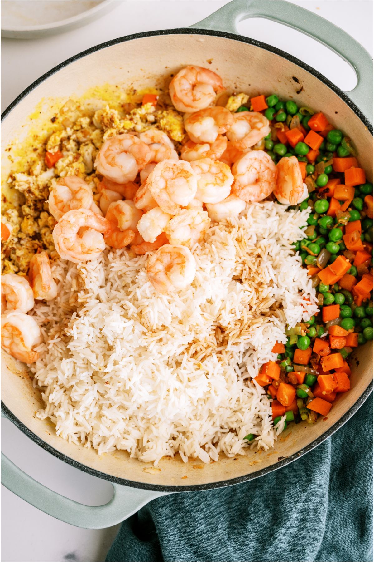 Ingredients for Shrimp Fried Rice in a skillet separated.